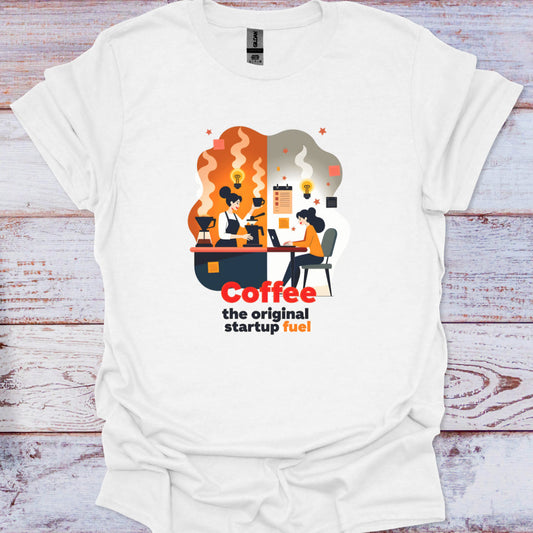 White t-shirt with a graphic design and text 'Coffee the original startup fuel' on a wooden surface.