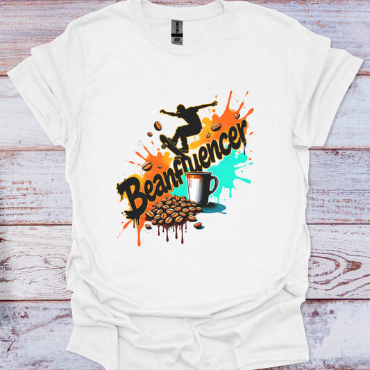 White t-shirt with colorful graphic design featuring a skateboarder, coffee cup, and text on a wooden background