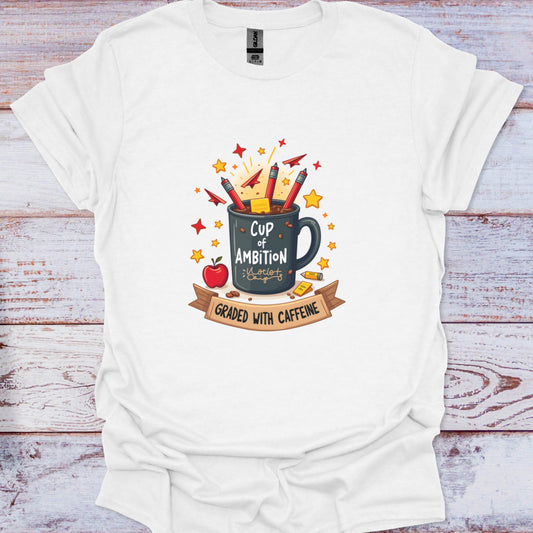 White t-shirt with a graphic design of a mug labeled 'Cup of Ambition' and text on a wooden background
