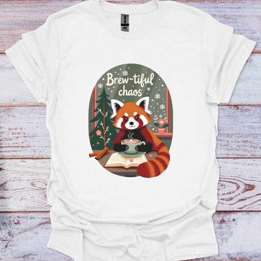 White t-shirt with a red panda holding a cup of coffee and the text 'Brew-tiful chaos' on a wooden surface.