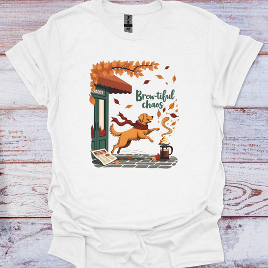 White t-shirt with a colorful graphic of a dog and coffee shop, text 'Brewtiful chaos', on a wooden surface.