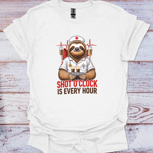 White t-shirt with a sloth in a doctor's outfit holding drinks and text 'Shot O'Clock is Every Hour' on a wooden surface.