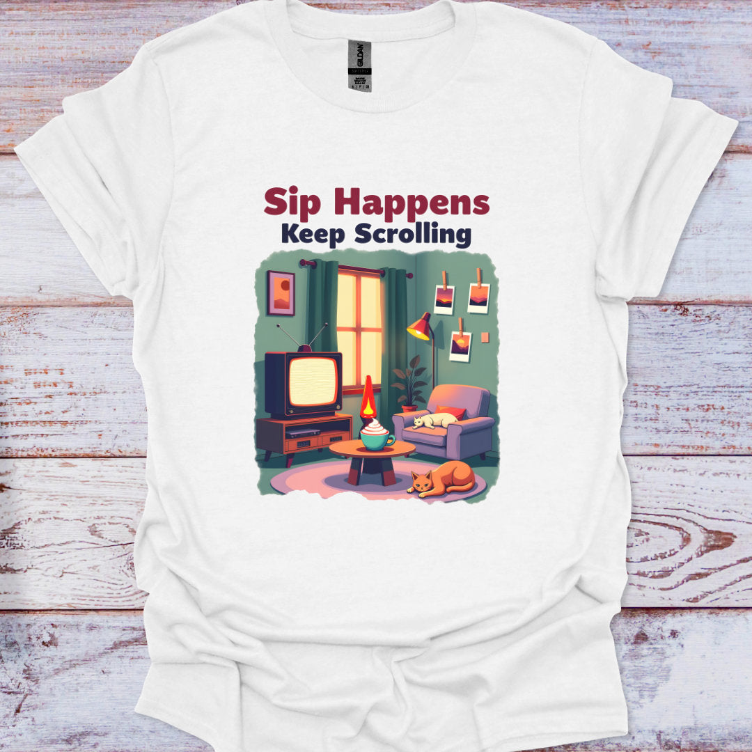 White t-shirt with a graphic of a living room and text 'Sip Happens Keep Scrolling' on a wooden surface.