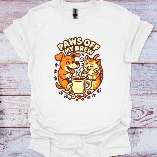 White t-shirt with a graphic of a dog and cat drinking coffee and 'Paws Off My Brew' text on a wooden surface.