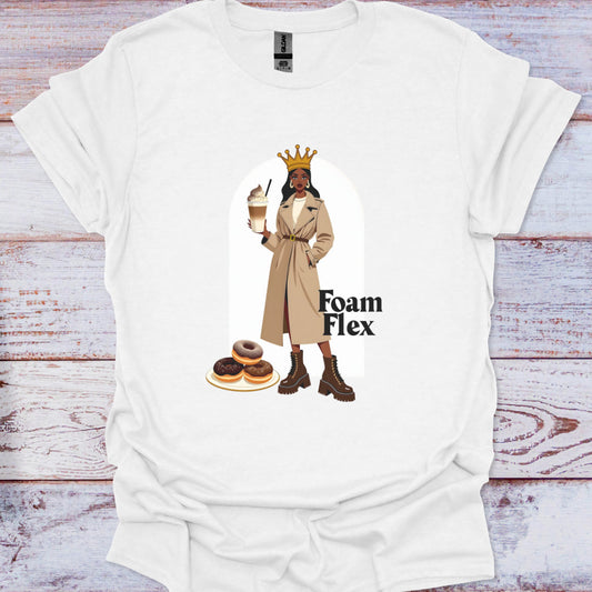 White t-shirt with a graphic of a woman, donuts, and 'Foam Flex' text on a wooden surface.