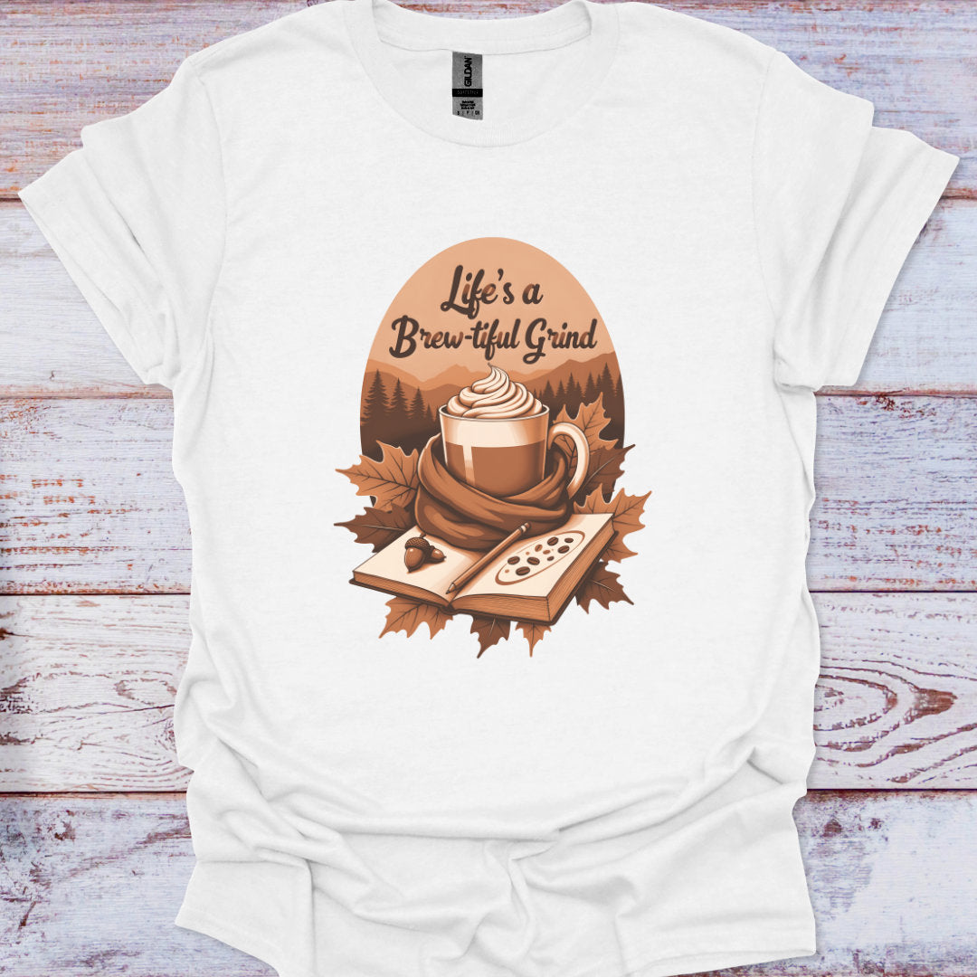 White t-shirt with a coffee-themed graphic and 'Life's a Brew-tiful Grind' text on a wooden surface.