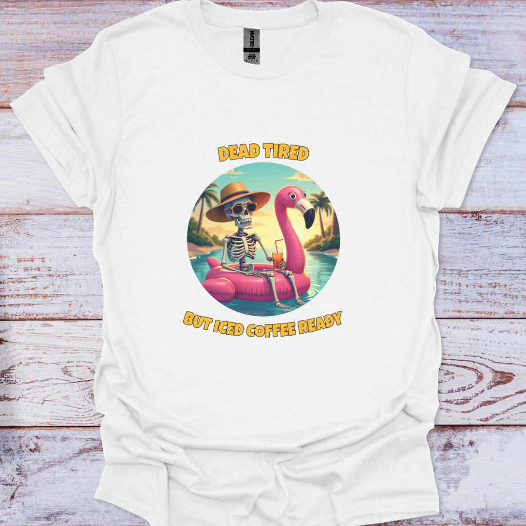 White t-shirt with a skeleton on a flamingo and text 'Dead Tired But Iced Coffee Ready' on a wooden surface