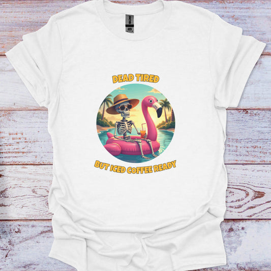 White t-shirt with a skeleton on a flamingo and text 'Dead Tired But Iced Coffee Ready' on a wooden surface