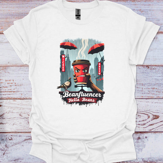 White t-shirt with a graphic design of a coffee cup character and text 'Beanfluencer Hella Beans' on a wooden surface.
