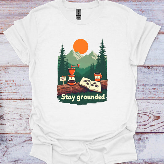 White t-shirt with 'Stay grounded' graphic design on a wooden surface