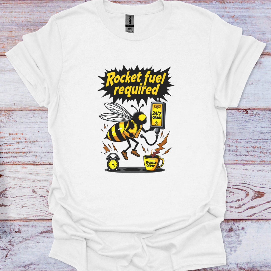 White t-shirt with a bee graphic and text 'Rocket fuel required' on a wooden surface